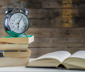 Alarm clock with books on a nightstand