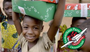 Smiling children with red and green Christmas gifts on top of their heads