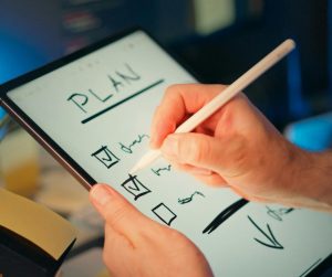 tablet with a pencil checking of planning boxes